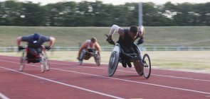 Паралельні спортсмени прискорюються вздовж спортивної траси в гонці на інвалідних візках — стокове фото
