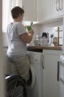 Junge Frau bereitet Tee in Wohnküche zu — Stockfoto