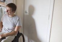 Sorrindo jovem mulher em cadeira de rodas em casa — Fotografia de Stock