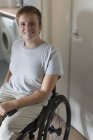 Portrait jeune femme souriante et confiante en fauteuil roulant à la maison — Photo de stock