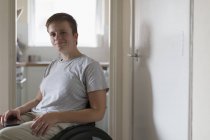 Ritratto giovane donna sicura di sé in sedia a rotelle a casa — Foto stock