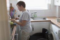 Mulher com cadeira de rodas cortando legumes na cozinha do apartamento — Fotografia de Stock