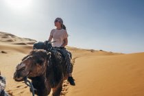 Жінка їзда верблюді в Сонячний піщаної пустелі, Сахара, Марокко — стокове фото
