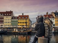 Paar genießt Blick auf Kanal und bunte Gebäude, Kopenhagen, Dänemark — Stockfoto