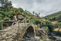 Женщина идет по идиллическому каменному мосту, Час-де-Эгуа, Португалия — стоковое фото