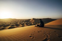 Viaggiatore maschile godendo di soleggiata vista sul deserto sabbioso, Sahara, Marocco — Foto stock