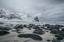 Rochers enneigés, plage isolée, Îles Lofoten, Norvège — Photo de stock