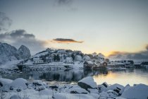 Ruhiges, schneebedecktes Fischerdorf direkt am Wasser, reine, erhabene Inseln, Norwegen — Stockfoto
