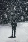 Snow falling over man — Stock Photo