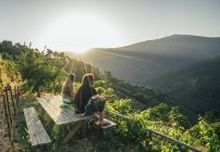 Pareja disfrutando de una vista soleada e idílica de la ladera, Chas de Egua, Portugal - foto de stock