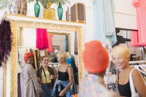 Giovani donne amiche shopping nel negozio di abbigliamento — Foto stock