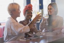 Счастливые, беззаботные молодые женщины-друзья пьют коктейльные бокалы в баре — стоковое фото