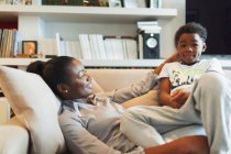 Любительська мати і син придушують диван у вітальні — стокове фото