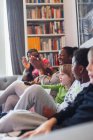 Felice famiglia battendo le mani sul divano del soggiorno — Foto stock