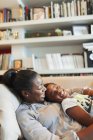 Happy mother and son cuddling on living room sofa — Stock Photo