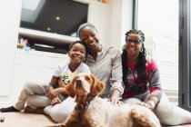 Portrait happy multi-generation family with dog on living room floor — Stock Photo