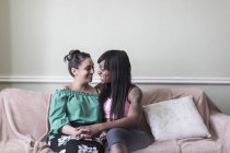 Cariñosa lesbiana pareja en sofá - foto de stock