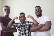 Retrato confiado hermanos adolescentes y hermanas flexionando los músculos - foto de stock