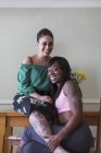 Retrato seguro, pareja lesbiana cariñosa con tatuajes - foto de stock