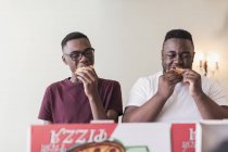 Teenage brothers eating pizza — Stock Photo