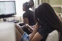 Mädchen schreibt SMS mit Smartphone im Wohnzimmer — Stockfoto