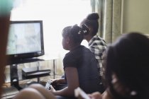 Tween girl friends playing video game in living room — Stock Photo