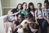 Lesbianas pareja y niños en sala de estar sofá - foto de stock