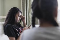 Між дівчиною смс з смартфоном — стокове фото