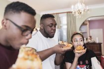 Teenage siblings eating pizza — Stock Photo