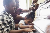 Hermano y hermanas tocando el piano - foto de stock