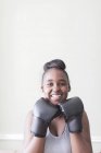 Portrait confident teenage girl wearing boxing gloves — Stock Photo
