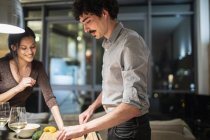 Couple cooking dinner in apartment kitchen at night — Stock Photo