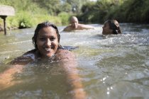 Портрет счастливая женщина плавает с семьей в солнечной реке — стоковое фото