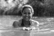 Щаслива жінка плаває в сонячній річці — стокове фото