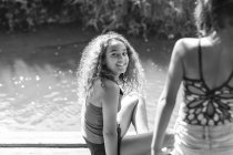 Retrato chica feliz a orillas del río soleado - foto de stock
