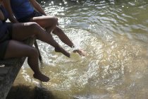 Family splashing legs in sunny river — Stock Photo