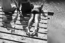 Famiglia che si rilassa sul molo sul lungofiume soleggiato — Foto stock