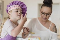 Мати і дочка прикрашати торт — стокове фото