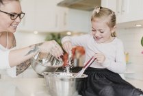 Mother and daughter baking in kitchen — Stock Photo