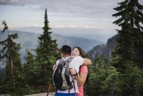 Caminhadas de casal feliz, abraçando na montanha, Dog Mountain, BC, Canadá — Fotografia de Stock