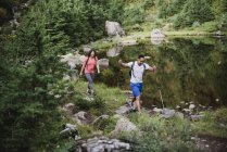 Couple hiking along lake in woods — Stock Photo