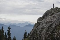 Randonneur debout sur le sommet d'une montagne accidentée, regardant la vue, Dog Mountain, BC, Canada — Photo de stock