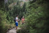 Couple hiking on remote trail in woods — Stock Photo