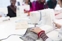 Diseñadora de moda femenina trabajando en la máquina de coser - foto de stock