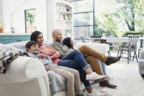 Семья смотрит телевизор на диване в гостиной — стоковое фото