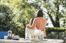 Affectionate mother and daughter on sunny morning patio — Stock Photo