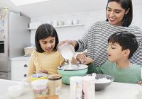 Mother and children baking in kitchen — Stock Photo