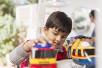 Junge spielt mit Spielzeughubschrauber und Feuerwehrauto — Stockfoto