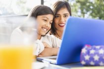 Mère heureuse et fille en utilisant un ordinateur portable — Photo de stock