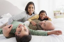 Счастливая семья обнимается на кровати — стоковое фото